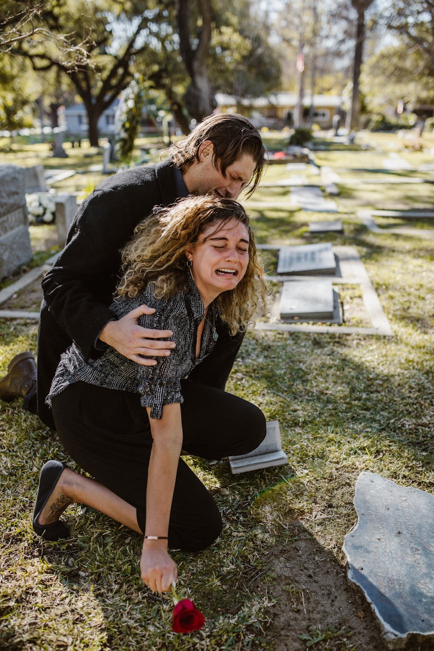 woman crying beside a man in a cemetery